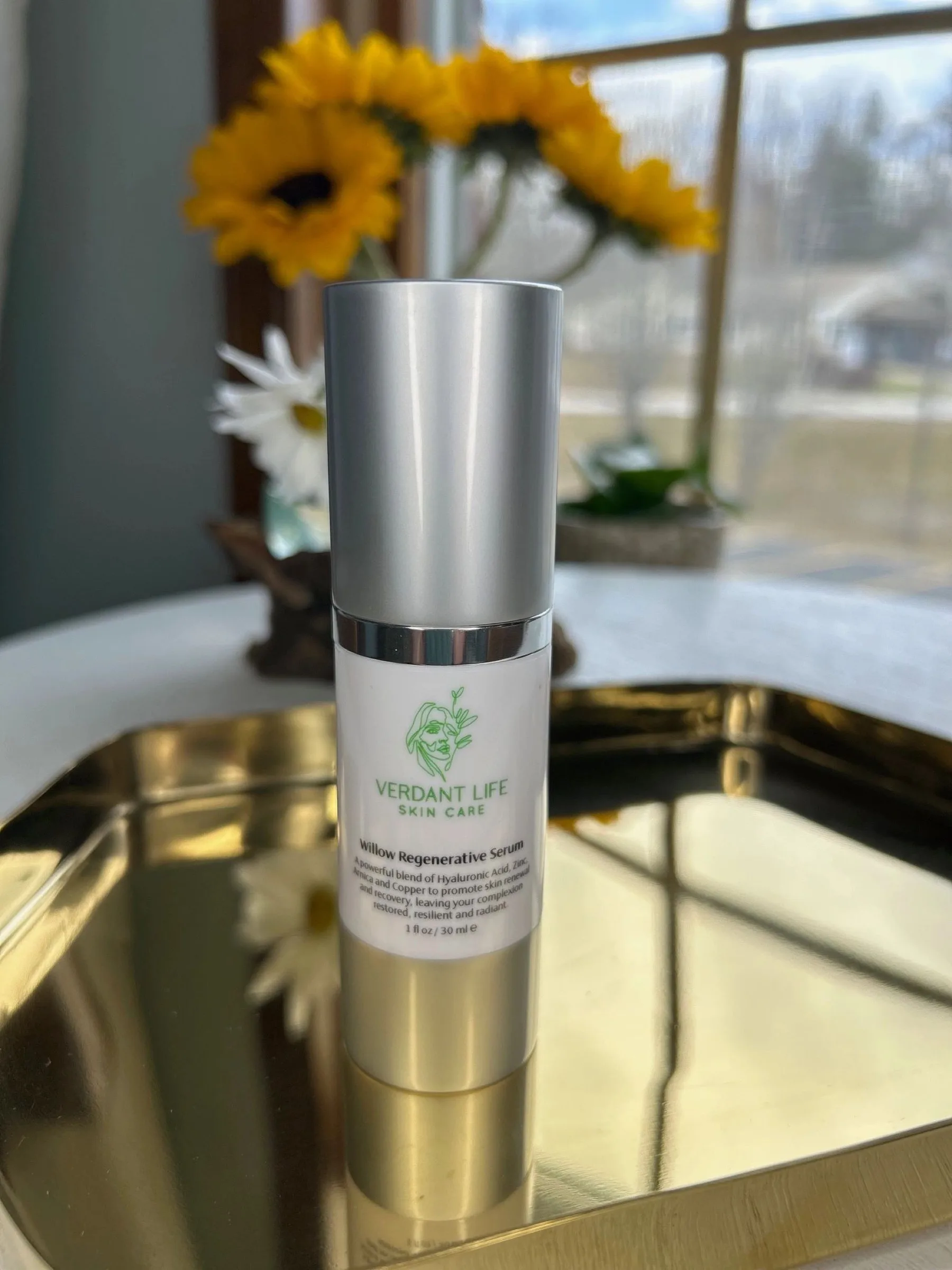 Silver-capped pump bottle of Willow Regenerative Serum on a gold tray.